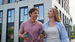 © stockbusters - Relaxed coworkers chatting outside with coffee walking near building closeup.