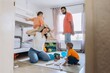 © Екатерина Лукашина - Happy family with two young sons playing together in a cozy children room. Father holds a red toy airplane while everyone laughs and enjoys quality time and bonding through play