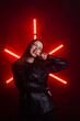 © kinomaster - Young Woman Posing with Neon Red Lights in Background