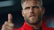 © JK_kyoto - Serious man with beard giving thumbs up gesture in sports outfit, expressive face, intense focus, background blurred