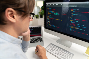 IT developer looking at online software development information on pc align working laptop with coding program on updated version application project trial creating new code overall system. Pecuniary.