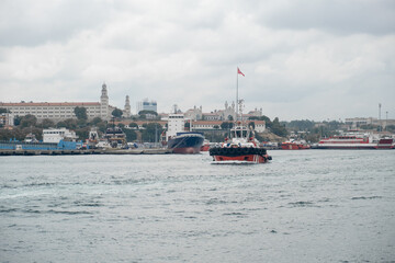 Poster - Bosphorus Strait showcasing tugboats and cargo ships under a cloudy sky during daytime