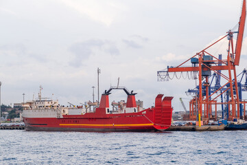 Poster - Bosphorus harbor with cargo ship at dock under cloudy skies and industrial cranes in the background
