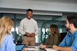 © insta_photos - Team leader, young happy African American male executive company manager discussing project management planning strategy working with diverse busy colleagues at office corporate board group meeting.