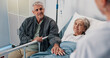 © Wesley25/peopleimages.com - Consultation, doctor and senior couple in hospital, conversation and cancer treatment. Healthcare, medical emergency or old woman in bed, elderly man and illness with recovery, wellness and support