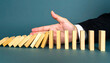 © ismail - Hand Stopping Falling Dominos Risk Management and Prevention Concept