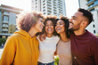 © DruZhi Art - Diverse Group of Friends Laughing Together – Young Multicultural People Embracing Outdoors in Urban Setting for International Friendship Day Celebrations and Cultural Unity Content