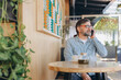 © anatoliycherkas - Senior freelancer working remotely from cafe, enjoying tea and talking on mobile phone
