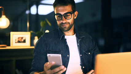 Fototapete - Internet, night and man in office, smartphone and message to contact, social media and chatting. Person, freelancer and employee in workplace, evening and cellphone with digital app and texting