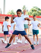 © Lumos sp - Young children having athletic exercise class running on the track, healthy lifestyle and children sport education concepts
