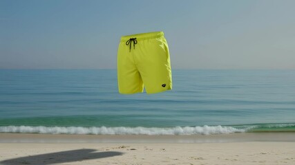 Wall Mural - Floating yellow shorts against tranquil beach and ocean waves in calm horizon scene