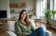 © Pete - Attractive smiling woman in home interior sitting in armchair. Brunette with long hair in casual attire relaxes smiling. Beautiful female in modern home looking at camera.