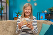 © Andrii Iemelianenko - Happy Caucasian mature woman counts money euro cash in hands after winning lottery bonus or receiving a gift. Grandmother smiles broadly sitting on home sofa, celebrating financial victory salary