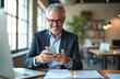 © Pete - Happy middle aged businessman using mobile phone. Smiling 50 years old man executive holding smartphone making online bank transaction payment in app, at office desk.