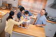 © Hip.hub - Family gathering in a bright kitchen as grandparents help toddlers enjoy snacks together