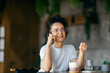 © Dusan Petkovic - Portrait of interracial young woman sitting in cafe and talking on her phone.