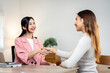 © Freedomz - Two women shaking hands in a room