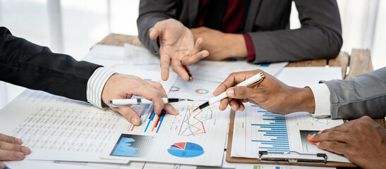 Fototapete - Three people are sitting at a table with papers and pens
