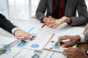 Fototapete - Three people are sitting at a table with papers and pens