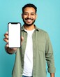 © luck - Happy Man Showing Blank Smartphone Screen, Mockup for App Presentation.  Smiling Indian Guy in Green Shirt Holding Mobile Phone with Empty Display. Perfect for Advertising and Mobile App Promotion.