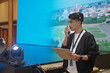 © Daniel Pawer - Asian male stage manager directs the show on stage using a headset, walkie-talkie, and clipboard, showing the professional work atmosphere behind the scenes of a show production.