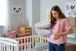 © Pixel-Shot - Young pregnant woman with pillows in children's room on moving day