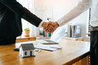 © Pormezz - Close up view hands of agent and client shaking hands after signed contract buy new apartment.