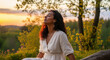 © Evans - Serene mixed-race woman relaxing, breathing fresh air outdoors at sunset. Peaceful mindfulness in nature, golden hour glow, calm meditation. Wellbeing and tranquility concept.
