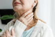 © shurkin_son - Closeup cropped image of unrecognizable aged female touching her throat being sick, feeling unwell, concerned of her thyroid dysfunction and pain, having endocrine disease of typical flue