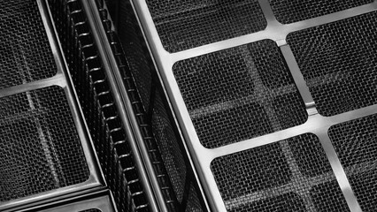 Poster - A close up of a black and silver mesh with squares. The mesh is made of metal and has a grid pattern
