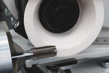 Poster - Machine with abrasive white disk used for sharpening milling cutter tool, industrial concept background
