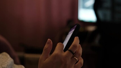 Aufkleber - Woman Using Her Phone While Sitting Comfortably in a Cozy Indoor Space During the Evening Hours