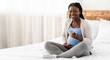 © Prostock-studio - Beautiful black pregnant woman relaxing on bed with cup of herbal tea, happy african expecting mother enjoying hot drink while resting in bedroom at home, smiling and looking at camera, copy space