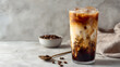 © Throm-Ka - Traditional Vietnamese iced coffee in a glass with condensed milk and ice cubes on a light neutral background