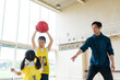 © metamorworks - バスケットボールをする子供たちと指導する男性