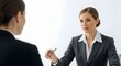 © Jessica - Businesswoman in suit holding pen while talking to another person indoors