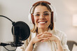 © Maria Vitkovska - Smiling woman radio host recording podcast in studio