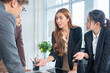 © panomporn - Group of confident professional business people pointing at graphs and charts to analyze marketing data to plan new sales strategies to increase productivity in modern office.