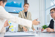© panomporn - Group of confident professional business people pointing at graphs and charts to analyze marketing data to plan new sales strategies to increase productivity in modern office.