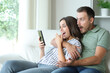 © Antonioguillem - Surprised couple checking mobile phone content at home