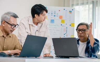Asian senior bootcamp team asking and  learning programming with software training and whiteboard collaboration