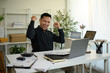 © saltdium - A Joyful, mature businessman celebrates a Career Milestone, raising his fists in triumph while smiling broadly, a Successful Business Achievement
