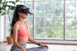 © weedezign - Asian woman wear virtual reality glasses choosing training yoga class online at home