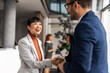 © Jelena - Professional Handshake Exchange Between Business People in Modern Office Setting