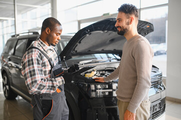 Fototapete - Mechanic, car servicing at garage - concept of timely customer service, car maintenance and deal agreemnet