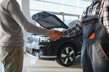 Fototapete - Repaired car. A close-up of a car mechanic and a client shaking hands