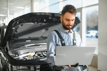Fototapete - Mechanic Uses a Computer with an Augmented Reality Diagnostics Software. Specialist Inspecting Car's Engine to Quickly Spot Broken Components. Premium Car Service
