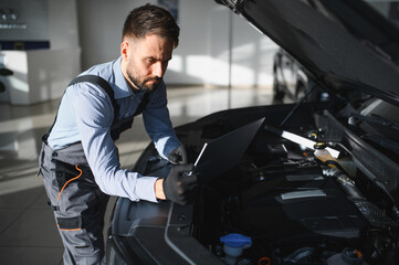 Fototapete - Troubleshooting process. Auto mechanic working in garage. Repair service