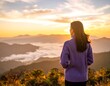© muhamad - Woman gazing at a sunrise mountain vista