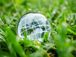 © NARONG - Crystal globe on grass with water droplets after rain in green forest - concept of environment, ecology and sustainable environment of the earth. Green business eco friendly on nature background.